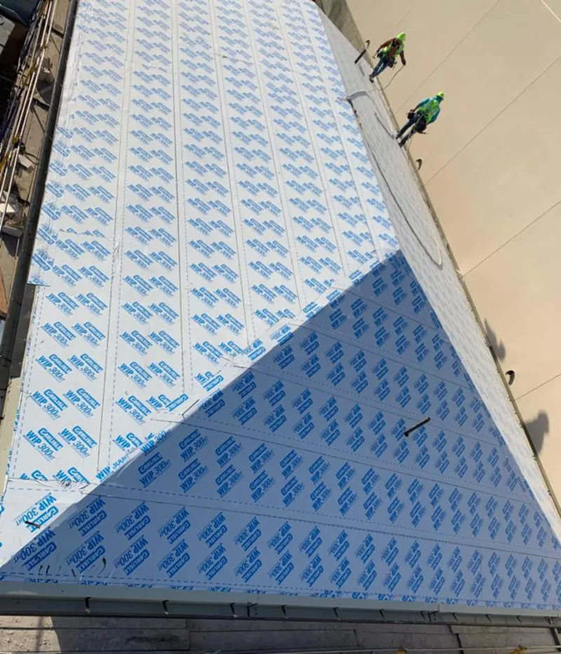 Professional roofers installing underlayment on a metal roof in Woodbridge